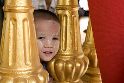 Gesicht eines kleinen burmesischen Jungen in der Anlage der Shwedagon Pagode in Yangon, Rangun, Myanmar, Burma