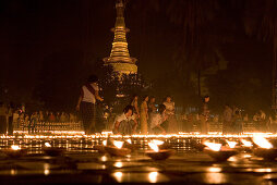 Buddhistische Gläubige zünden Kerzen an, Gelände der Botataung Pagode bei Nacht, Yangon, Rangun, Myanmar, Burma
