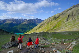 group of hikers descending from hut Similaunhütte down towards reservoir Vernagtsee, Ötztal range, South Tyrol, Italy