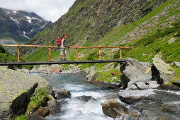 junge Frau auf Brücke über Bach, Lazinstal, Texelgruppe, Ötztaler Alpen, Südtirol, Italien