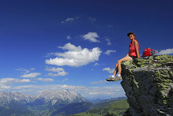 Woman sitting on rock, Berchtesgaden Alps in background, Salzburg, Austria