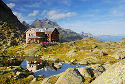 hut Bremer Huette and reflections in little lake, Habicht in background, Stubaier Alpen range, Stubai, Tyrol, Austria