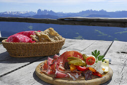 Brotzeit serviert in einem Bergrestaurant, Dolomiten im Hintergrund, Sarntaler Alpen, Südtirol, Italien
