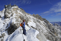 Woman on ridge to summit of mount Zugspitze, Wetterstein range, Upper Bavaria, Bavaria, Germany