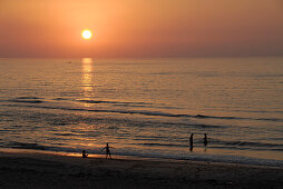 Menschen baden bei Sonnenuntergang im Meer, Musandam, Oman, Asien
