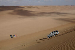 Ein Geländewgen fährt eine Sanddüne hinunter, Wahiba Sands, Oman, Asien