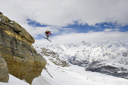 Freerider springt über einen Felsen am Stockhorn, Zermatt, Wallis, Schweiz
