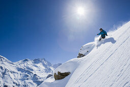 Skifahrer mit Telemark Ski bei der Abfahrt im Tiefschnee, Zinal, Wallis, Schweiz