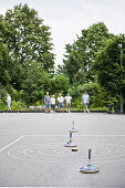 Eine Gruppe Senioren spielen Stockschiessen, Freizeit, Park, Oberhaching, Bayern, Deutschland