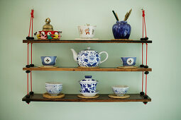 Decorated souvenir shelf with antique asian teapot, cups