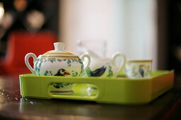 Green tray with tea dishes on a table