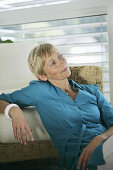 Mature woman looking through window, Styria, Austria