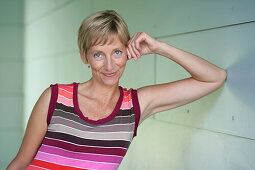 Mature woman leaning against wall, Styria, Austria