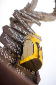 Rucksack hängt an einem Wegweiser, Wettersteingebirge, Bayern, Deutschland