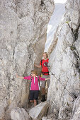 Hikers crossing wind gap, Werdenfelser Land, Bavaria, Germany