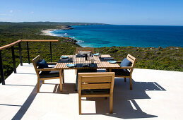 Ein gedeckter Tisch auf der Terrasse der Southern Ocean Lodge im Sonnenlicht, Blick auf Hanson Bay, Kangaroo Island, Südaustralien, Australien