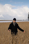 Senior man standing in dried grass, Windach, Upper Bavaria, Germany