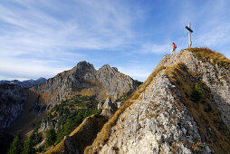 Frau genießt die Aussicht am Gipfelkreuz des Brunnenkopfs, Ammergauer Alpen, Pfaffenwinkel, Bayern, Deutschland