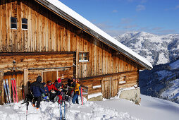 Backcounty skiiers resting at alpine hut, Wiedersberger Horn, Kitzbuehel Alps, Tyrol, Austria