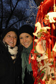 Two young women visiting Christmas market, Frauenchiemsee, Chiemgau, Bavaria, Germany