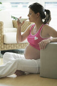 Pregnant woman drinking a glass of milk, Styria, Austria