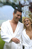 Young couple wearing bathrobes at the garden of a hotel, South Tyrol, Italy, Europe