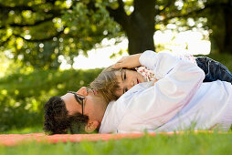 Vater und Tochter liegen auf einer Wiese, Englischer Garten, München, Bayern, Deutschland