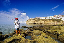 Angler on the beach under blue sky, Carvoeiro, Algarve, Portugal, Europe