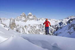 Frau auf einer Skitour, Drei Zinnen im Hintergrund, Cadinigruppe, Dolomiten, Trentino-Alto Adige, Italien