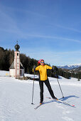 Cross-country skier, chapel in background, Dolomite Alps, Trentino-Alto Adige/Südtirol, Italy