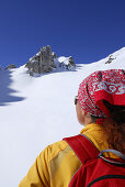 Woman looking at snow field, Tajatoerl, Mieminger range, Ehrwald, Tyrol, Austria