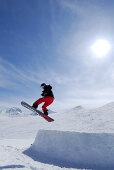 Snowboarder jumping from a kicker, ski area Soelden, Oetztal, Tyrol, Austria