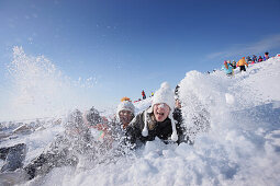 Three children playing in snow, Muensing, Bavaria, Germany