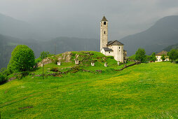 Church in Rossura on a hill with meadow, valley Leventina, Ticino, Switzerland