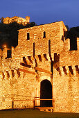 Zugbrücke der Burg Castello di Montebello, beleuchtet, mit Castello di Sasso Corbaro im Hintergrund in UNESCO Weltkulturerbe Bellinzona, Bellinzona, Tessin, Schweiz