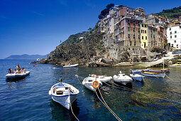 Rubber dingi and fishing boats at harbour under blue sky, Riomaggiore, Cinque Terre, Liguria, Italian Riviera, Italy, Europe