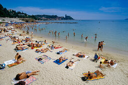 Menschen sonnen sich am Strand unter blauem Himmel, Golfo della Spezia, Italienische Riviera, Ligurien, Italien, Europa