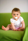 Baby girl (8 Month) useing pacifier looking at camera, Vienna, Austria