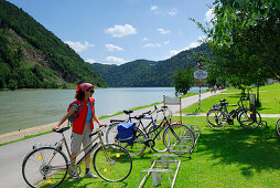 Woman near bicycle stand, Schloegener Schlinge, Danube cycle route Passau to Vienna, Schloegen, Upper Austria, Austria