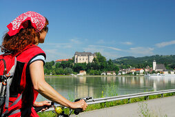 Frau blickt über die Donau auf Grein, Oberösterreich, Österreich