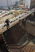 Chimney sweep on corrugated iron roof, Berlin, Germany