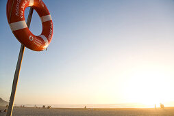 Rettungsring auf Pfahl, Strand bei Sonnenuntergang, Atlantik, beliebter Strand von Windsurfern, Praia de Odeceixe, Algarve, Portugal