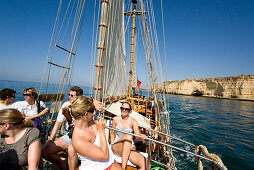 Touristen, Maedchen fotografieren sich auf dem Deck, Segelschiff Santa Bernada, fuer touristische Zwecke umgebautes altes Segelschiff, Fahrten entlang der Felsenkueste, Portimao, Algarve, Portugal