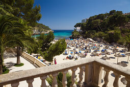 Blick auf Strand mit Sonnenschirmen in der Bucht Cala Santanyi, Mallorca, Balearen, Mittelmeer, Spanien, Europa