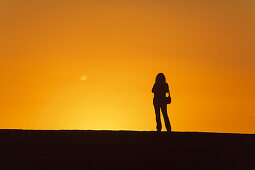 Frau betrachtet den Sonnenuntergang, Puerto de Tazacorte, UNESCO Biosphärenreservat, La Palma, kanarische Inseln, Spanien, Europa