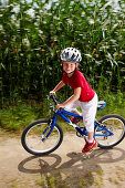 Girl (6-7 years) riding bicycle, Bavaria, Germany