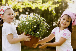 Amusement, Caucasian, Caucasians, Child, childhood, Children, Color, Colour, Companion, Companions, Contemporary, Daytime, exterior, Female, flower, Flowerpot, Flowerpots, flowers, Friend, Friends, Fun, Garden, Gardening, Gardens, Girl, Girls, grin, grinn