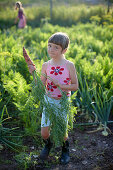 Girl (6-7 years) holding carrot, Lower Saxony, Germany