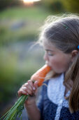 Girl (8-9 years) eating a carrot, Lower Saxony, Germany