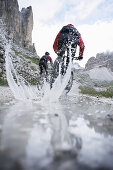 Persons mountain biking near Tre Cime di Lavaredo, Veneto, Italy